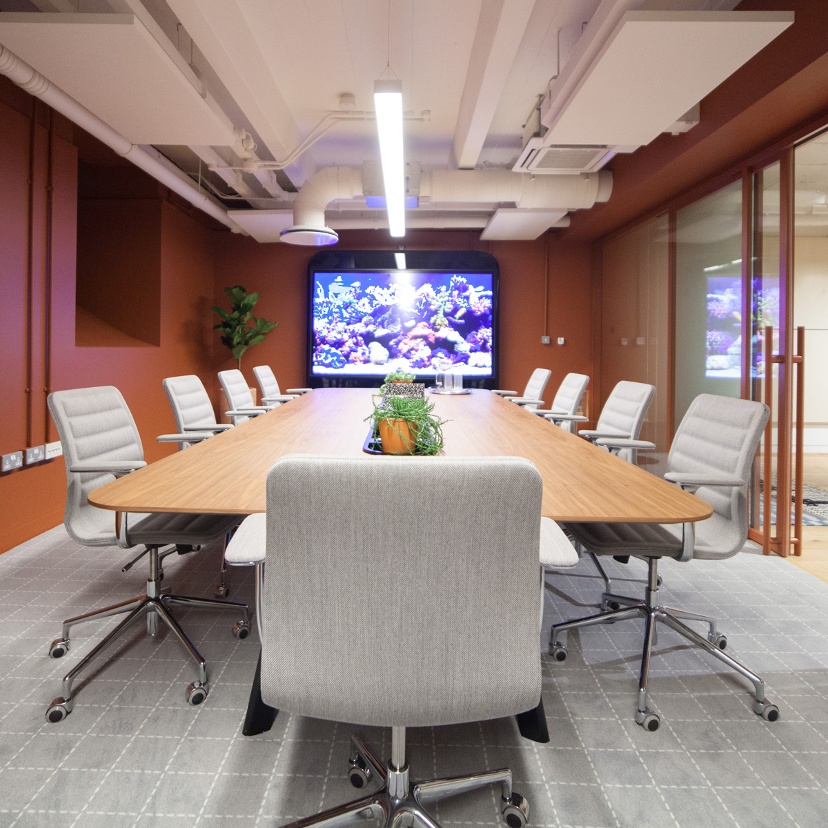 Long meeting table with lots of office chairs