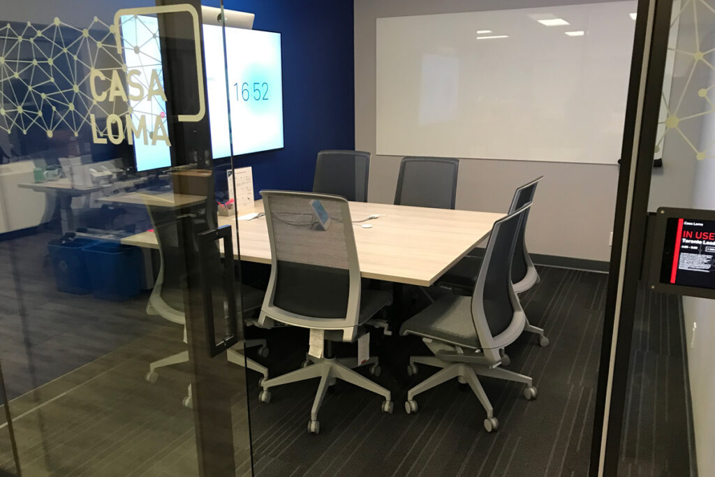 Small meeting room with a table and six office chairs