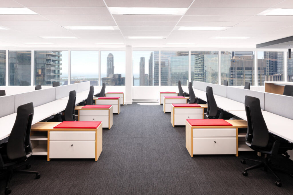 Two rows of desks with office chairs and cabinets